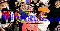 Kanak-kanak berpakaian kostum dan topeng halloween. Kumpulan tipu muslihat atau pelayan yang berdiri di atas tangga dengan pakaian Halloween mereka. Percutian